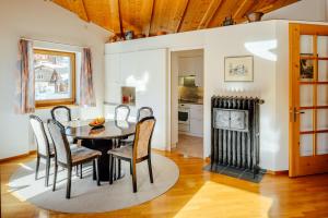 a dining room with a table and chairs and a fireplace at Edelweiss Flora Sura in Flims