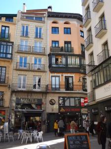 een gebouw in een stad met tafels en stoelen bij Atico en la Plaza del ayuntamiento in Pamplona