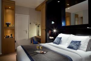 a hotel room with a bed with a tray of wine glasses at Marceau Champs-Elysées in Paris