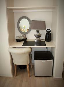 escritorio con silla, lámpara y espejo en B&B Villa Verde en De Haan