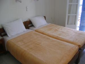 two beds sitting next to each other in a room at La Fontana in Naxos Chora
