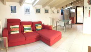 a red couch in a living room with a table at Attico with swimming pool in Lenno