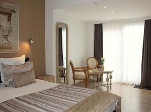 a bedroom with a bed and a table and a chair at B&B Villa Verde in De Haan