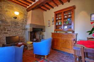 a living room with a table and a television at Villa Calcinaio by PosarelliVillas in Cortona