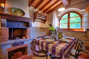 una sala da pranzo con tavolo e camino di Villa Calcinaio by PosarelliVillas a Cortona