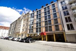 ein großes Gebäude mit davor geparkt in der Unterkunft Hotel Aurbacher Hof GmbH in München