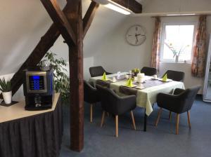 a dining room with a table and chairs and a tv at Hotel am Maibaum in Neuenrade
