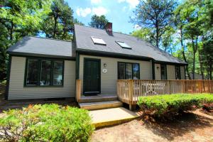 una pequeña casa con porche y valla en Cape Cod Holiday Estates, a VRI resort, en Mashpee