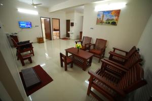 a living room with a table and chairs and a television at Indeevaram Residency in Trivandrum