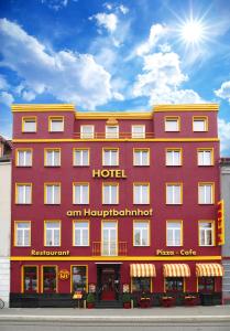 
a red brick building with a yellow building behind it at Hotel am Hauptbahnhof in Schwerin
