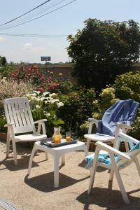 Dos sillas y una mesa con zumo de naranja. en Chambres d'hôtes - Les Palmiers en Corseul