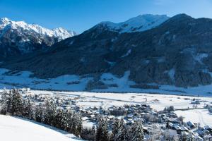 a village in the snow with mountains in the background at Apartment Wanger in Neukirchen am Großvenediger