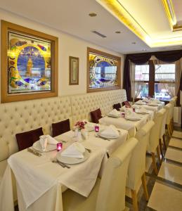 una fila de mesas en un restaurante con mantel blanco en GLK PREMIER Acropol Suites & Spa, en Estambul