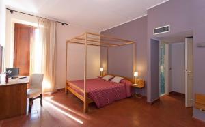 a bedroom with a canopy bed and a desk at Hotel Palazzo Ducale in Diamante +32 photos