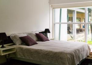 a bedroom with a bed and a large window at Quinta da Mafalda in Mira