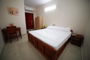 a bedroom with a large bed and a chair at Indeevaram Residency in Trivandrum
