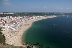 an aerial view of a beach with a crowd of people at Estúdio - Nazaré in Nazaré
