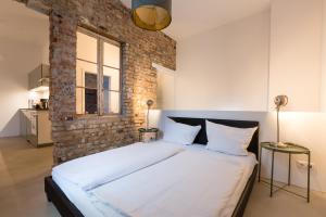 une chambre avec un grand lit avec un mur de briques dans l'établissement Loft in the middle of Berlin, à Berlin