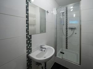 a white bathroom with a sink and a shower at Ferienwohnung Meiselbach in Erfurt