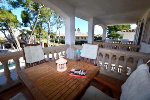 アルクーディアにあるApartamento Cerca De La Playaの木製のテーブルと椅子が置かれたポーチ