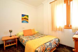 アルクーディアにあるApartamento Cerca De La Playaのベッドルーム1室(ベッド1台、テーブル、窓付)