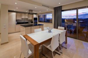 a kitchen and dining room with a white table and chairs at Vila Castelo Parque in Ferragudo