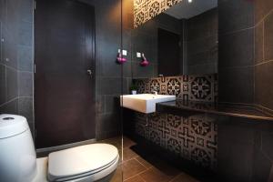 een badkamer met een wit toilet en een wastafel bij Backyard Rio Melaka in Melaka