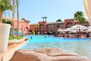a pool at a resort with people swimming in it at Savoy Le Grand Hotel Marrakech in Marrakech