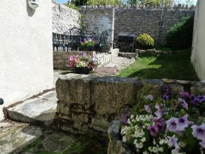 a garden with flowers and a stone wall at Seapinks Cottage in Portland