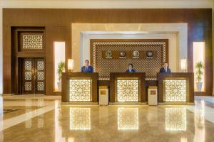 a group of three men standing at the podium in a lobby at Savoy Le Grand Hotel Marrakech in Marrakech