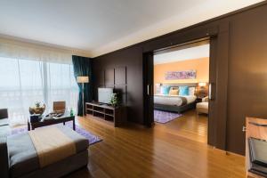a bedroom with a bed and a living room at Savoy Le Grand Hotel Marrakech in Marrakech