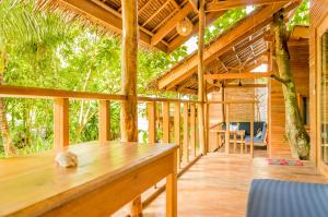 a porch of a wooden house with a tree at Amihan Bungalows in General Luna