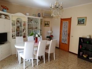 アルゲーロにあるAppartamento Mosasのダイニングルーム(テーブル、白い椅子付)