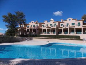 um grande edifício com uma piscina em frente em Charming Villa Albufeira em Albufeira