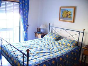 ナザレにあるCasa da praiaのベッドルーム1室(青い掛け布団、窓付)