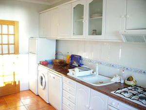 ナザレにあるCasa da praiaのキッチン(白い冷蔵庫、洗濯機付)