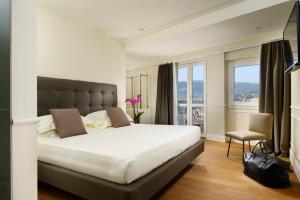 a bedroom with a large bed and a large window at Locanda della Posta Boutique Hotel in Perugia