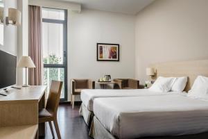 a hotel room with a large bed and a desk at Hotel Exe Barcelona Gate in Sant Joan Despí