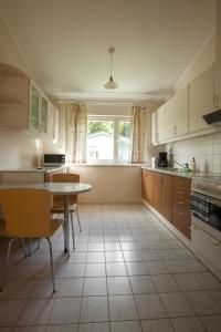 a kitchen with a table and a table and a window at Liivakell Holiday Homes in Narva-Jõesuu