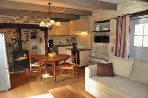 a kitchen and living room with a couch and a table at Gites de Combarel in Corn