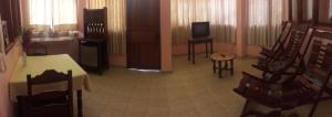 una camera con tavolo, sedie e televisore di La Isla de los Tucanes a Rurrenabaque