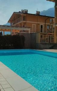 uma piscina azul em frente a uma casa em Attico with swimming pool em Lenno