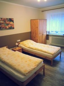 a room with three beds and a window at Pension Jahnkes Gasthaus in Todesfelde