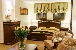 a bedroom with a bed and a vase of flowers on a table at Sodeliškių dvaro sodyba in Sodeliškiai