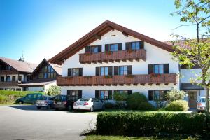 ein Gebäude mit Autos auf einem Parkplatz in der Unterkunft Hotel garni Sterff in Seeshaupt