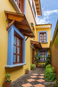 a yellow and blue house with potted plants at Hotel Posada Real Tapalpa in Tapalpa