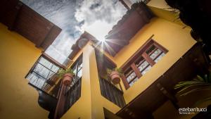 a yellow building with windows and the sun in the sky at Hotel Posada Real Tapalpa in Tapalpa
