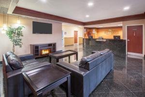 a lobby with two leather couches and a fireplace at Baymont by Wyndham South Haven in South Haven