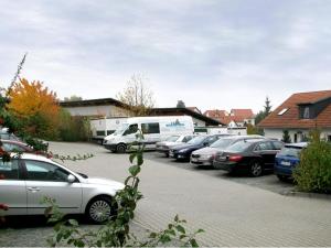 eine Reihe von Autos auf einem Parkplatz in der Unterkunft Hotel am Platz in Hohenmölsen