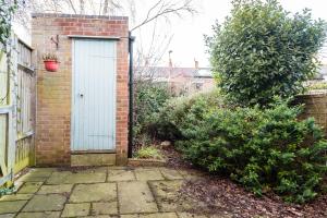 a brick house with a white door in a yard at The Jericho Escape - Comfortable & Modern 4BDR House in Oxford